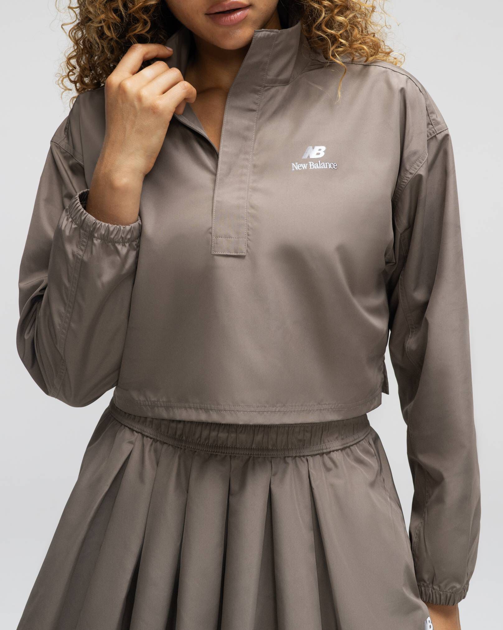 A woman standing against a grey studio backdrop