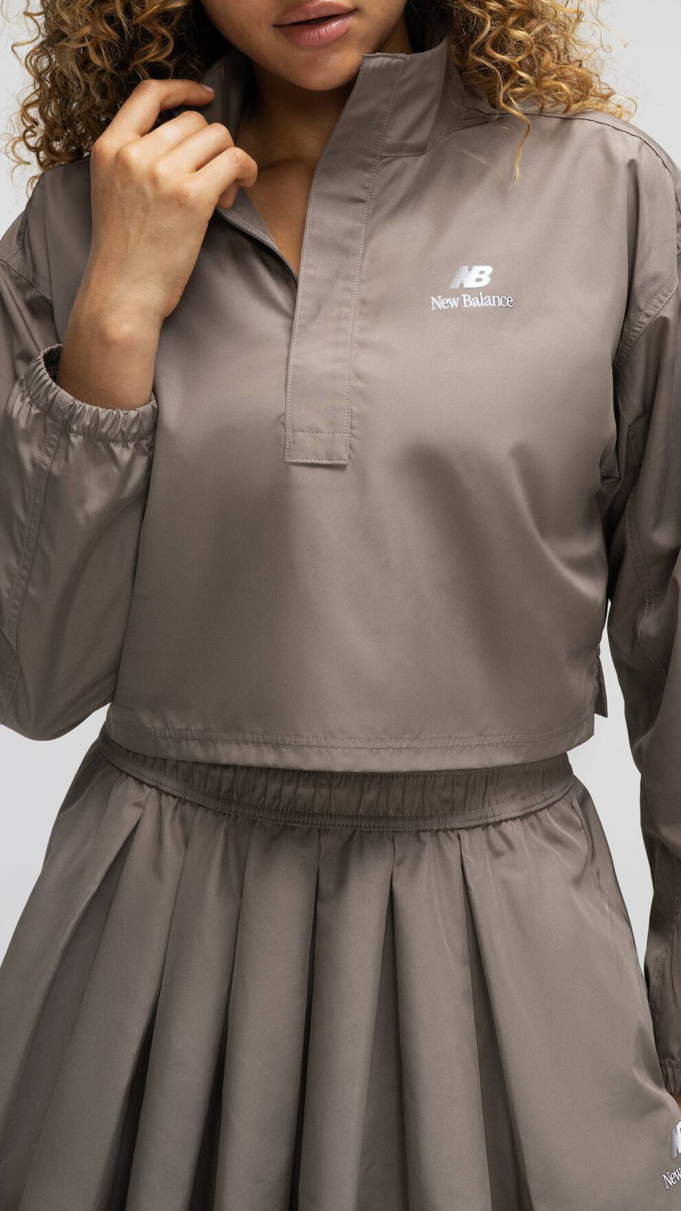 A woman standing against a grey studio backdrop