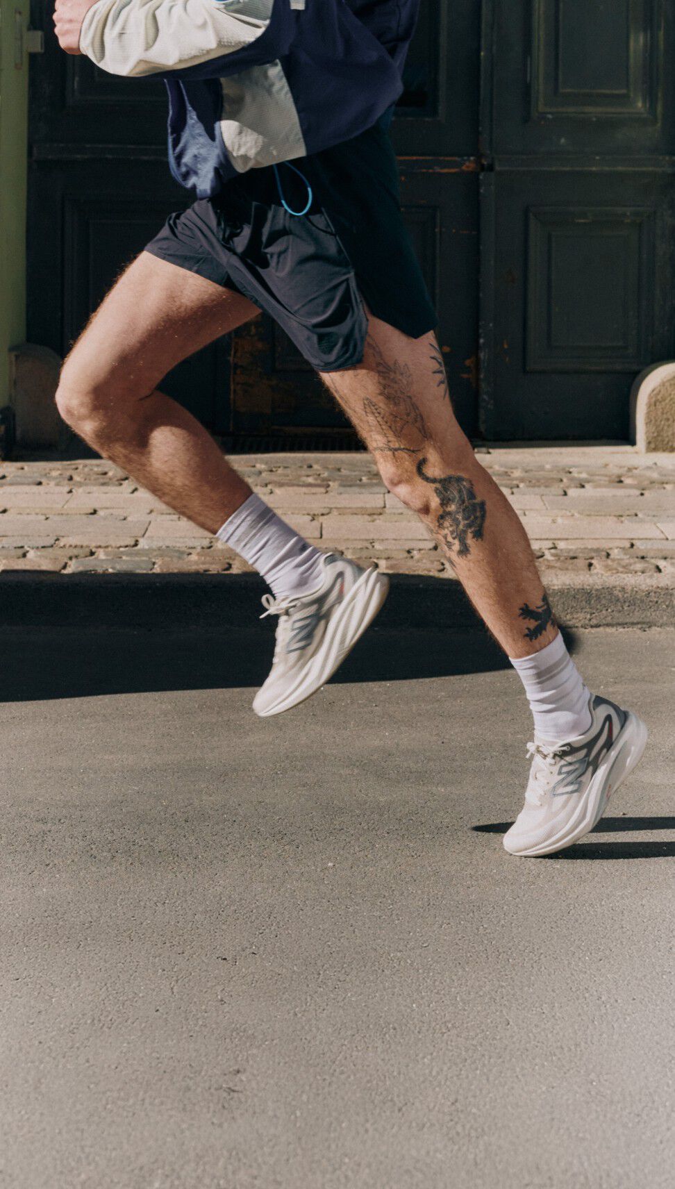 Close up of a man running on a street in New Balance sneakers.
