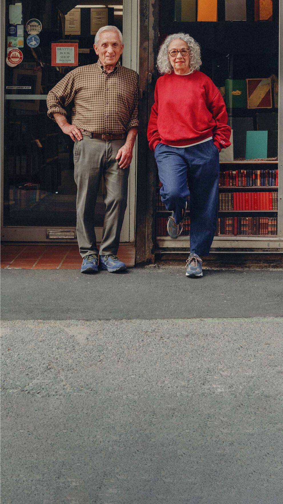 A man and woman standing on the street in front of a bookstore.